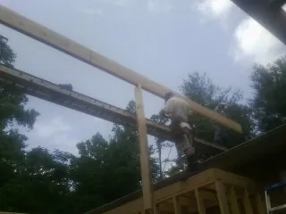 Carpenter setting a ridge beam over a new addition frame — Ice Dam Removal by Roofing Brothers in Harshaw