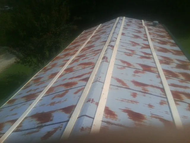 Rusted metal roof panels with new wood purlins before replacement — Storm Damage Roof Repair in Harshaw by Roofing Brothers