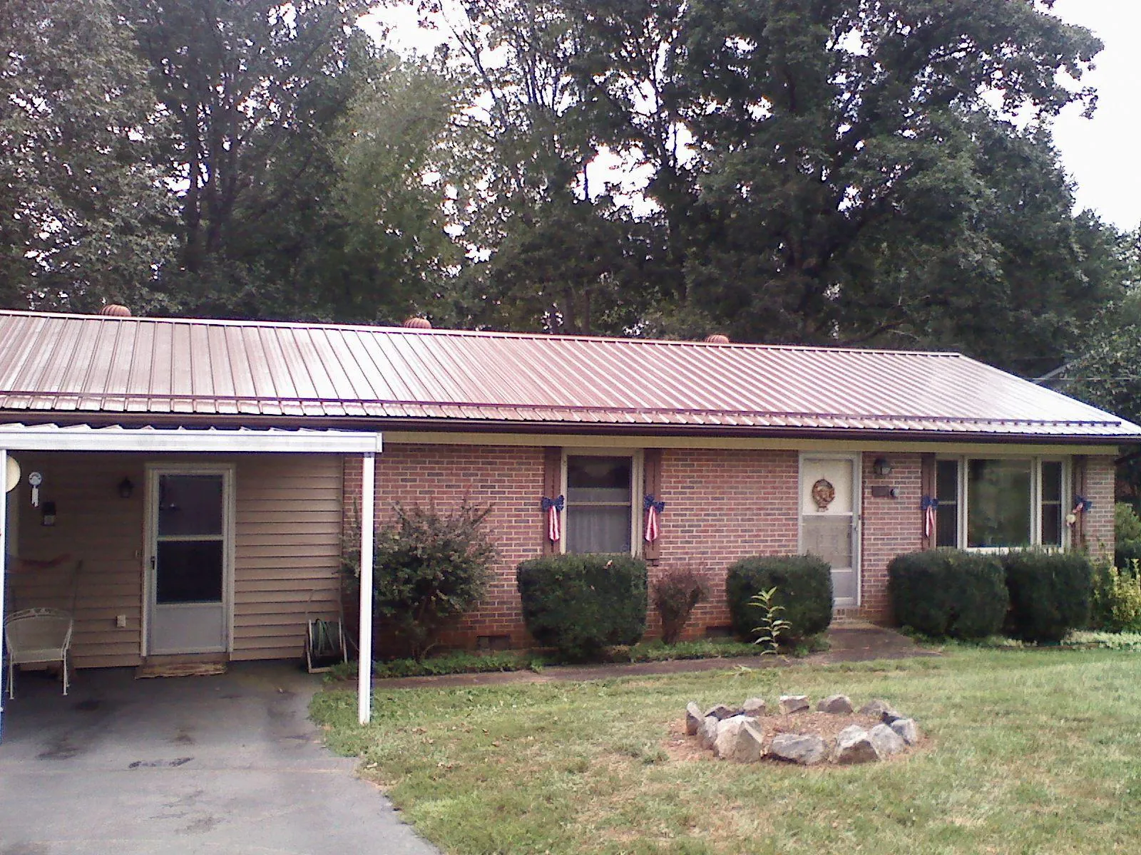 Bronze metal roof and carport on a brick ranch home — Roof Repair work by our crew in Harshaw
