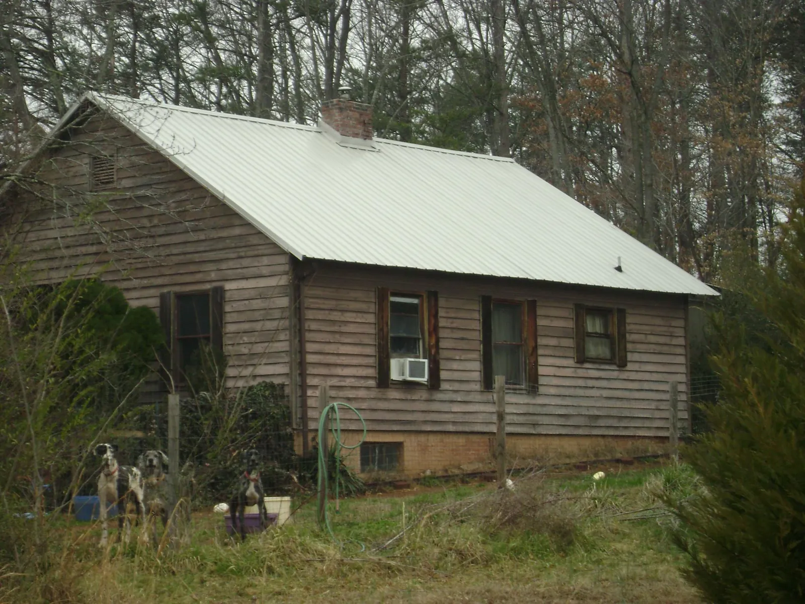 White metal roof on an old wood sided farmhouse, from a Metal Roof Installation job in Harshaw